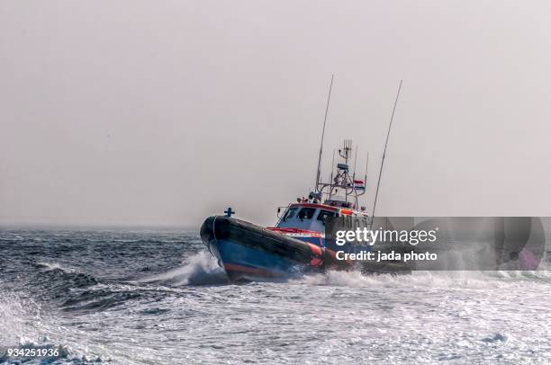 lifeboat at full speed - mitglied der küstenwache stock-fotos und bilder