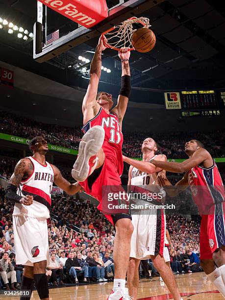 Brook Lopez of the New Jersey Nets dunks in front of Joel Przybilla of the Portland Trail Blazers during a game on November 25, 2009 at the Rose...
