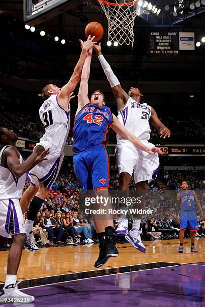 David Lee of the New York Knicks takes the ball to the basket against Spencer Hawes and Jason Thompson of the Sacramento Kings on November 25, 2009...