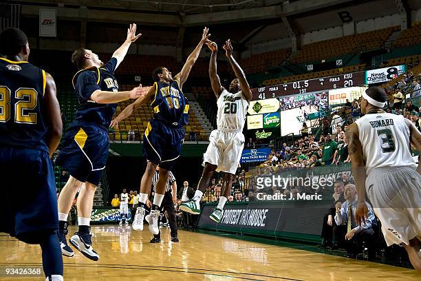 Dominique Jones of the South Florida Bulls shoots over defenders Frank Henry-Ala and Brandon Parks of the Kent State Golden Flashes during the game...