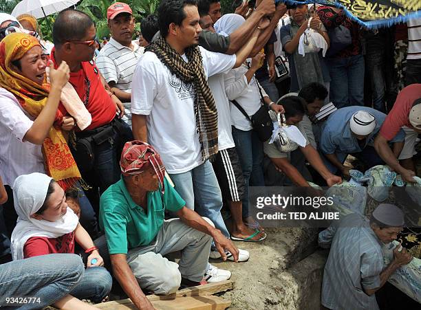 Relatives of the Mangudadatu family mourn as one of the family members is buried in the family cemetery in Buluan, Maguindanao province on November...