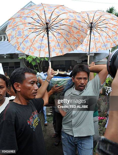 Supporters carry the body of one of the family members of the Mangudadatu prior to the funeral in Buluan, Maguindanao province on November 26, 2009....
