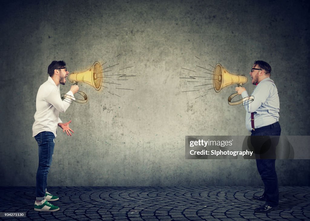 Businessmen screaming into a megaphone at each other