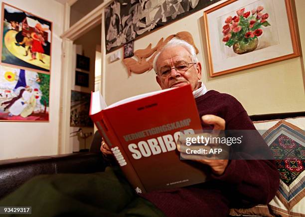Jules Schelvis whose wife Rachel died at the Sobibor death camp in Poland, reads a book about the camp in his home in Amstelveen on November 23,...