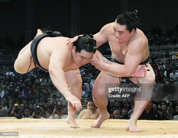 Mongolian sumo grand champion Asashoryu is thrusted down in the ring by his compatriot Harumafuji during a 12th day bout of the Kyushu Grand Sumo...