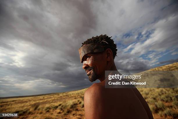 San Bushmen from the Khomani San community walks through grass in the Southern Kalahari desert on October 15, 2009 in the Kalahari, South Africa. One...