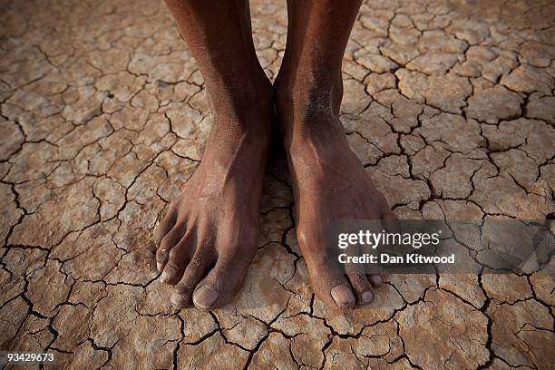 Bushman from the Khomani San community stands on a dry pan, in the Southern Kalahari desert on October 15, 2009 in the Kalahari, South Africa. One of...