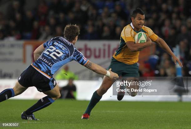 Kurtley Beale of Australia, despite being held by Gavin Evans, makes a break with the ball to set up the first try during the match between Cardiff...