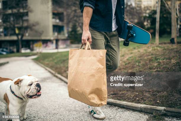 man and dog in the park - grocery bag stock pictures, royalty-free photos & images
