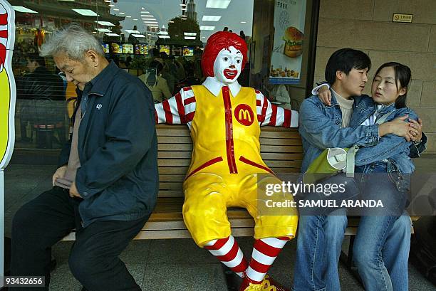 Picture taken in November 2004 shows a couple sitting in the door of Mc Donald's restaurant in Xian, China. Mc Donalds will be celebrating the 50th...