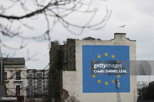 Mural by British artist Banksy, depicting a workman chipping away at one of the stars on a European Union themed flag, is pictured in Dover, south...