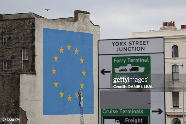 Mural by British artist Banksy, depicting a workman chipping away at one of the stars on a European Union themed flag, is pictured in Dover, south...