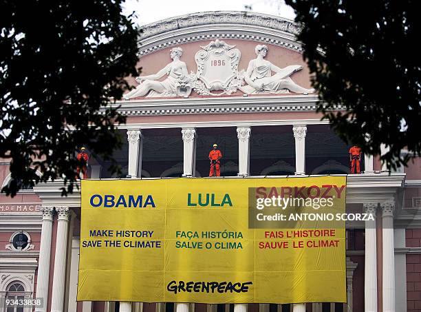 Greenpeace activists display a banner on the facade of Amazon teather, November 26, 2009 in Manaus, demanding Presidents of the US, Brazil and France...