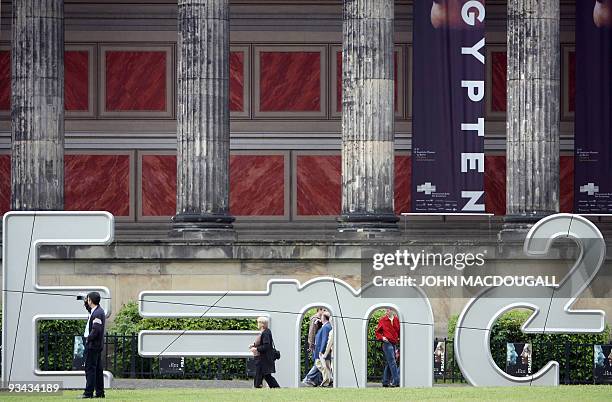People walk past a giant sculpture featuring Albert Einstein's formula "E=mc2" in front of Berlin's Altes Museum 19 May 2006. The sculpture, the last...
