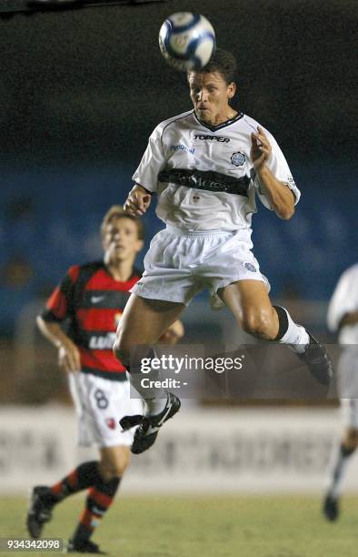 Miguel Benitez, of Paraguay's Olimpia, hits the ball with his head, as Juninho , of Brazil's Flamengo, watches 06 March 2002, during the Copa...
