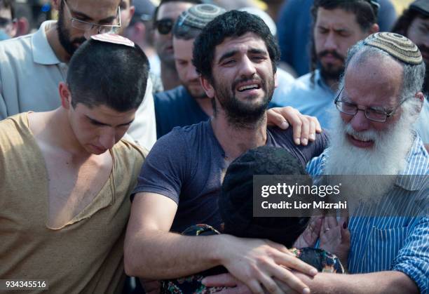 Family members mourn next to the grave of Israeli Adiel Coleman during his funeral on March 19, 2018 in Kochav Hashahar settlement, West Bank....