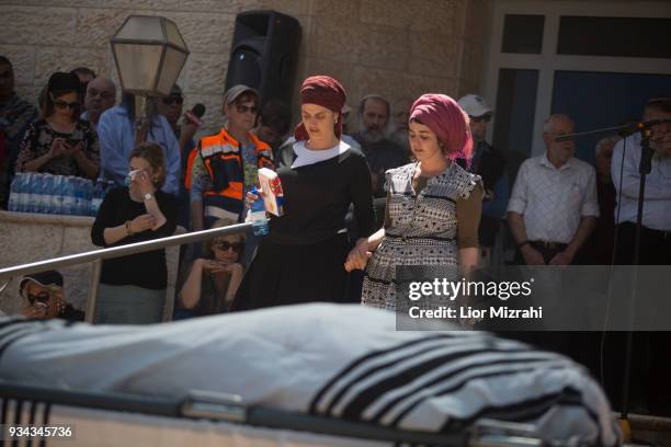 Family members and friends mourn next to the body of Israeli Adiel Coleman during his funeral on March 19, 2018 in Kochav Hashahar settlement, West...