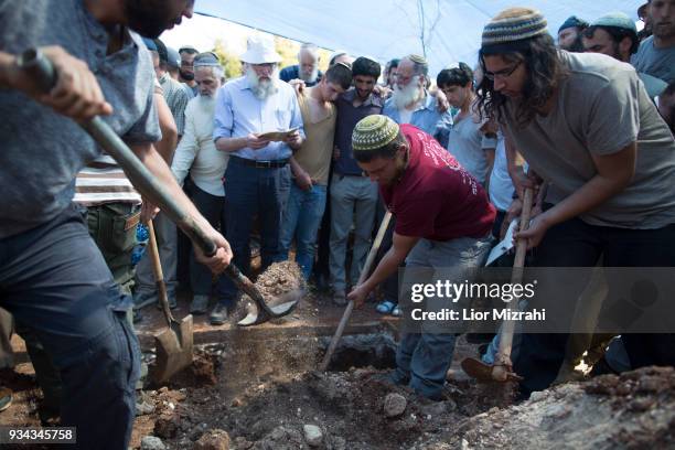 Family members stand next to the grave of Israeli Adiel Coleman during his funeral on March 19, 2018 in Kochav Hashahar settlement, West Bank....