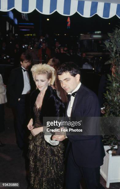 British comedian Rowan Atkinson with his girlfriend, actress Leslie Ash, at the premiere of the James Bond film 'Never Say Never Again', 1983.