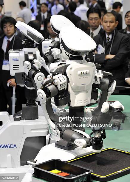 Japan's machinery maker Kawada Industries' new robot Nextage, equipped with 15 actuators and two cameras, collaborate and assemble blocks during a...