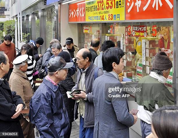 People queue up at the window of a Tokyo booth to purchase tickets for the 300 million yen Year End Jumbo Lottery on November 24, 2009. Thousands of...