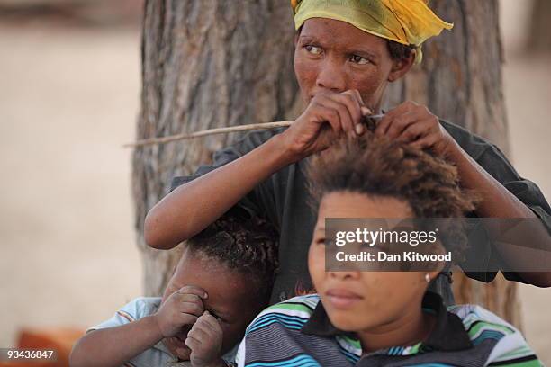 San Bushwomen from the Khomani San community styles a young girls hair in the Southern Kalahari Desert on October 15, 2009 in the Kalahari, South...