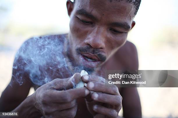 San Bushmen from the Khomani San community smokes a bone pipe in the Southern Kalahari Desert on October 16, 2009 in the Kalahari, South Africa. One...