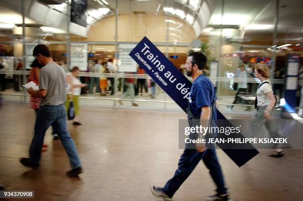 Un ouvrier de maintenance de la gare de Lyon Part-Dieu porte un panneau d'information, le 02 juin 2005, alors qu'un mouvement de grève perturbe le...