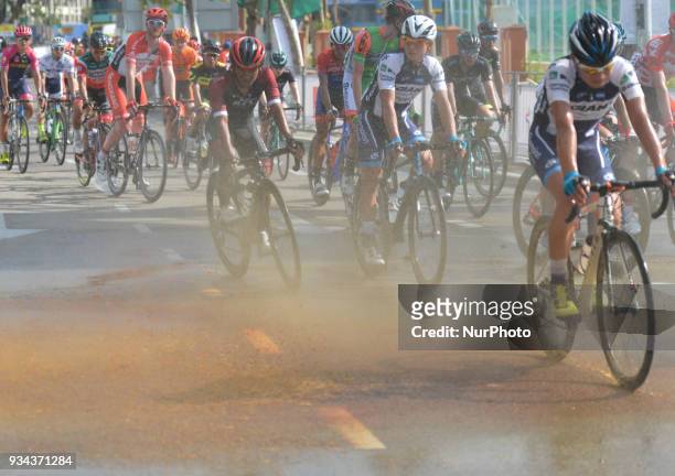 Cyclists of the final group after crossing the finish line try to avoid 'a dirty shower' at the end of the second stage, a 208.3km from Gerik to Kota...