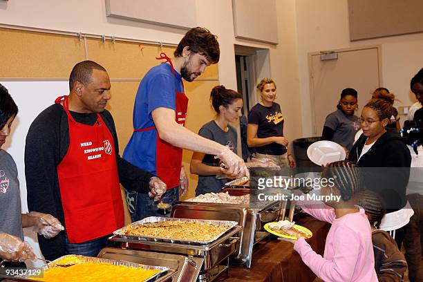 Lionel Hollins, head coach of the Memphis Grizzlies and Marc Gasol of the Memphis Grizzlies serve Thanksgiving dinner to women and children on...