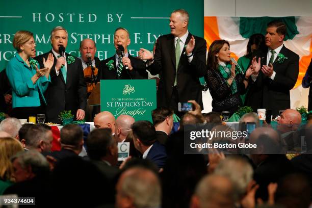 From left, U.S. Senator Elizabeth Warren sings with Boston City Councilor Michael Flaherty and Congressman Stephen F. Lynch as Massachusetts Governor...