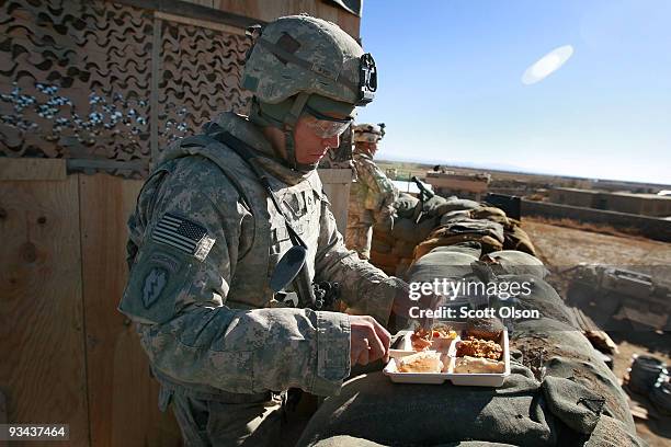 Joshua Korder of Winona, MN with Blackfoot Company 1st Battalion 501st Parachute Infantry Regiment has Thanksgiving dinner while standing watch in a...