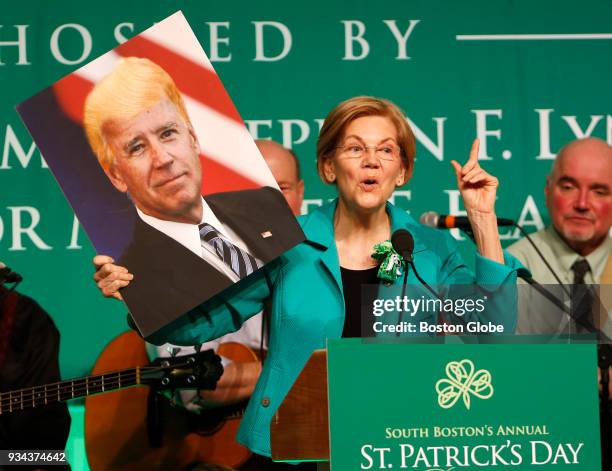 Senator Elizabeth Warren holds up a picture of Joe Biden with Donald Trump's hair during the annual St. Patrick's Day Breakfast at the Ironworkers...