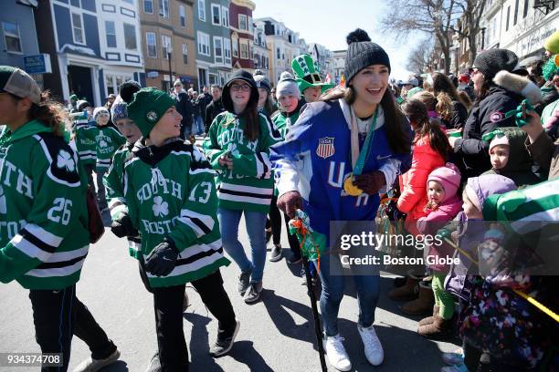 Women's hockey team member Megan Keller, center, takes part in the annual St. Patrick's Day parade in South Boston on March 18, 2018.