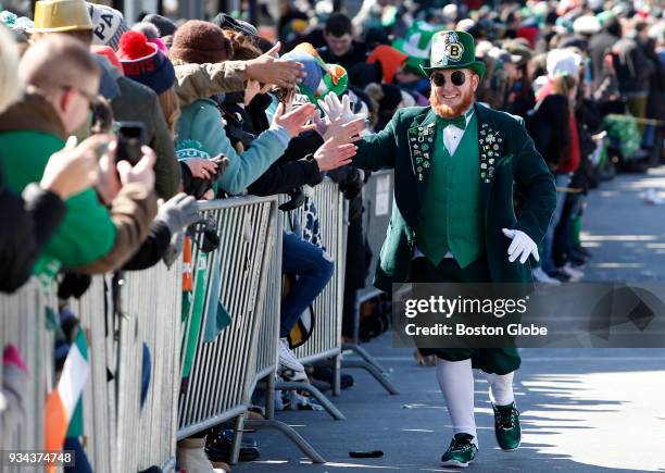 Matt Casey, who goes by Casey the Leprechaun, high-fives people along the annual St. Patrick's Day parade route in South Boston on March 18, 2018.