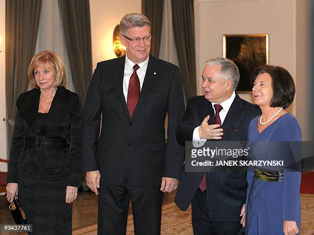 Polish President Lech Kaczynski with his wife Maria gestures as they welcome Latvia's counterpart Valdis Zatlers and his wife Lilita on November 26,...