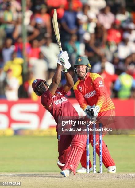 Brendan Taylor of Zimbabwe looks on as Rovman Powell of The West Indies scores runs during The Cricket World Cup Qualifier between The West Indies...