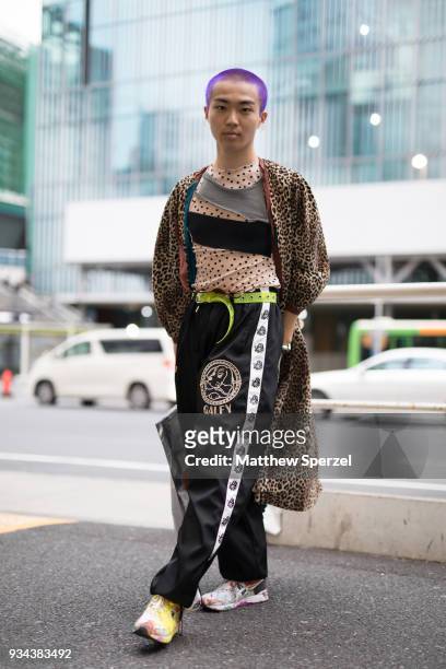 Guest is seen wearing a leopard print coat with black track pants, sneakers, and neon green belt during the Amazon Fashion Week TOKYO 2018 A/W on...