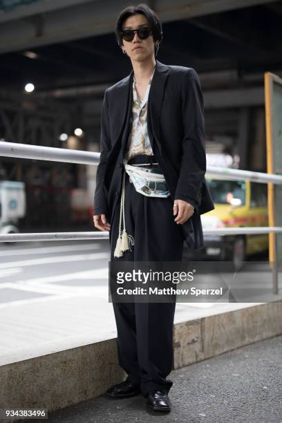 Guest is seen wearing a black blazer and pants with PVC hip bag, gold sash belt and black shoes during the Amazon Fashion Week TOKYO 2018 A/W on...