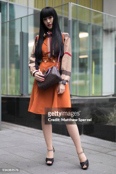 Guest is seen wearing an orange/brown dress with brown bag during the Amazon Fashion Week TOKYO 2018 A/W on March 19, 2018 in Tokyo, Japan.