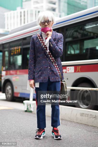 Guest is seen wearing a purple pattern blazer, navy stripe pants, pink turtleneck, and multi-color sneakers during the Amazon Fashion Week TOKYO 2018...