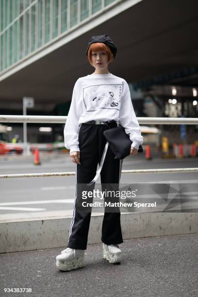 Guest is seen wearing a white sweater, black track pants, white platform shoes and black beret during the Amazon Fashion Week TOKYO 2018 A/W on March...