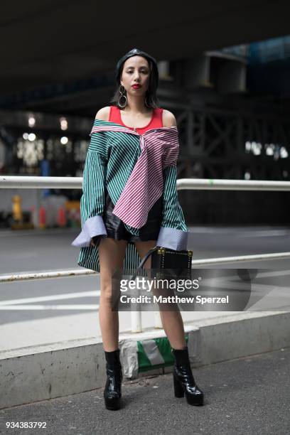 Guest is seen wearing a green/red stripe oversize shirt with red tank top, beret, and black shoes and bag during the Amazon Fashion Week TOKYO 2018...