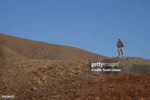 David Young of Quincy, Ca with the Army's 1st Battalion 501st Parachute Infantry Regiment surveys the surrounding area from a hilltop during a patrol...