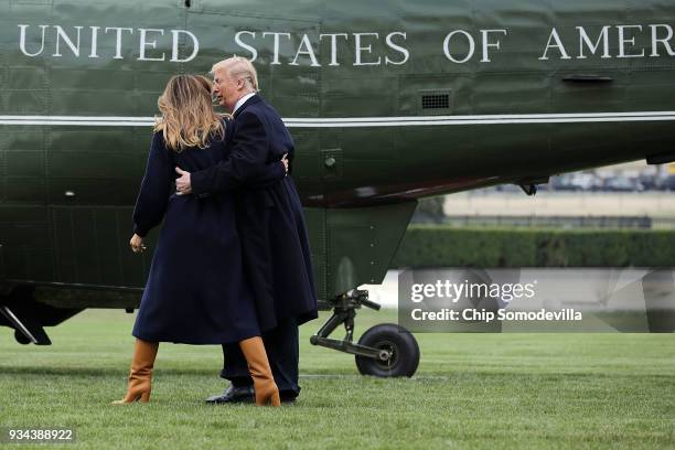 President Donald Trump and first lady Melania Trump put their arms around each other after she lost her footing while walking across the South Lawn...