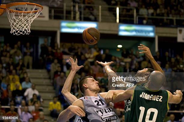 Arturas Jomantas of Lietuvos Rytas vie for the ball with Augusto Cesar Lima and Carlos Jimenez of Unicaja during their Euroleague basketball match at...