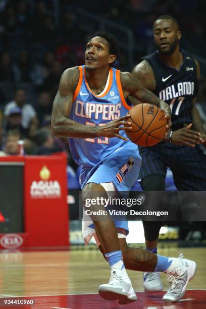 Lou Williams of the Los Angeles Clippers steps to the basket past Jonathon Simmons of the Orlando Magic during the NBA game between the Orlando Magic...