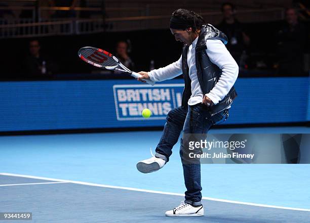 Manchester City Carlos Tevez flicks the ball up while playing tennis after Juan Martin Del Potro of Argentina won his men's singles round robin match...
