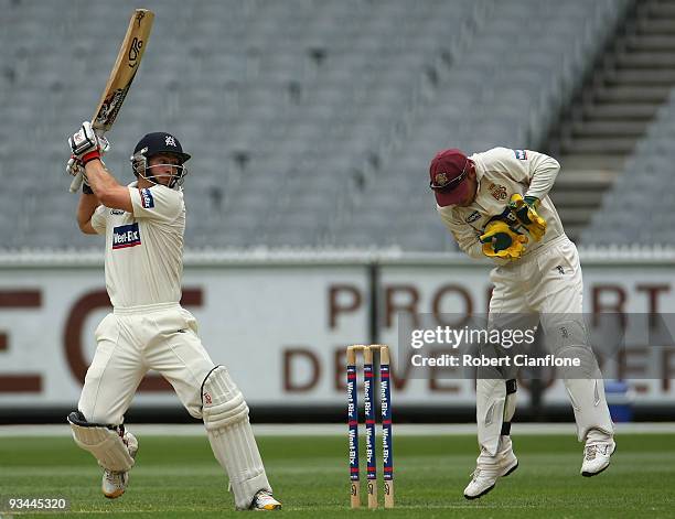 Matthew Wade of Victoria plays a shot past Queensland wicketkeeper Chris Hartley during day one of the Sheffield Shield match between the Victorian...