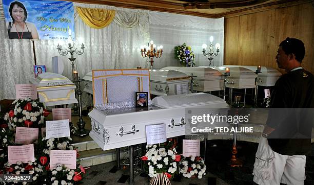Man views the coffins of journalists killed in an election-related massacre in the southern Philippine province of Maguindanao at a funeral parlor in...
